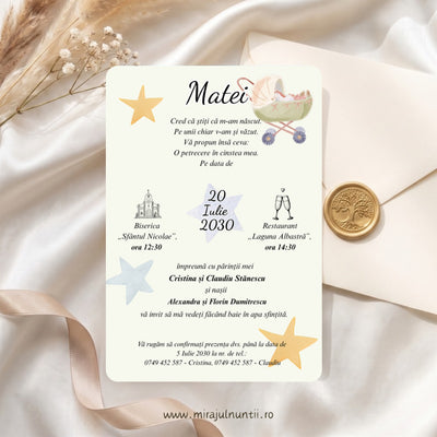 Invitație de botez cod Magnific B.7-20007 pe fond crem, cu cărucior de bebeluș în acuarelă în dreapta sus, steluțe aurii și bleu, numele Matei scris caligrafic și data pe steluța albă, între biserică și paharele de șampanie