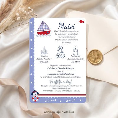 Invitație de botez tipărită cu bărcuță cu pânze în carouri bleu, pește roșu și cățeluș marinar cu colac, bandă bleu cu stele și dungi roșii, numele Matei și textul invitației, pe satin alb lângă un plic crem cu sigiliu auriu