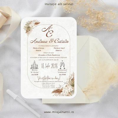 Invitație de nuntă cod Magnific C.30 pe carton alb satinat, cu pampas, orhidee albe și chenar arcuit auriu, în teracotă și crem, lângă un plic crem.