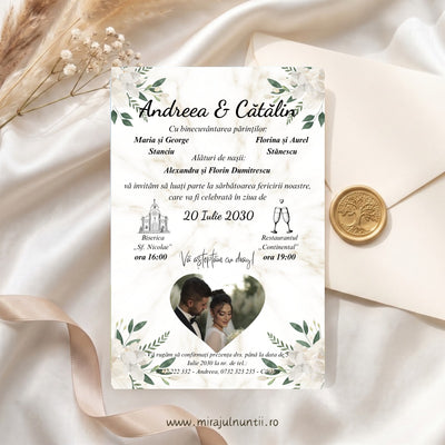 Invitație de nuntă C.43: numele Andreea & Cătălin, părinții și nașii, data 20 Iulie 2030, biserica și restaurantul, iar jos fotografia mirilor într-o inimă; flori crem și frunze verzi în colțuri, pe fond crem cu marmură discretă, lângă un plic crem cu sigiliu de ceară
