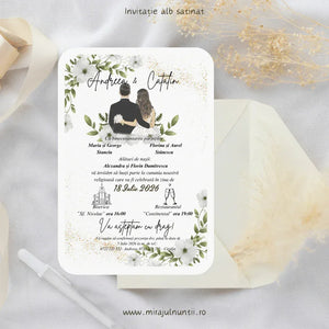 Invitație de nuntă cod Magnific C.9 pe carton alb satinat, cu ilustrația mirilor îmbrățișați văzuți din spate, flori albe și frunze verzi, lângă un plic crem.