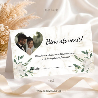 Set 50 plicuri de bani nuntă C.43, fața: fotografia mirilor într-o inimă, „Bine ați venit!”, mesajul de mulțumire și rândul „Familia:”, flori crem și frunze verzi, pe fond crem cu marmură discretă