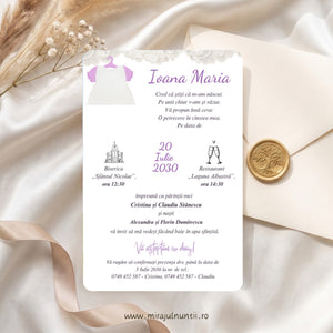 Invitație de botez B. 7608 tipărită, cu bandă de dantelă albă sus și rochiță albă de botez cu mânecuțe roz-lila pe umeraș, numele Ioana Maria și data scrise cu lila, lângă un plic crem cu sigiliu auriu