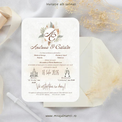 Invitație de nuntă cod Magnific C.29 pe carton alb satinat, cu monogramă încadrată de flori uscate și pampas în teracotă și bej, lângă un plic crem.