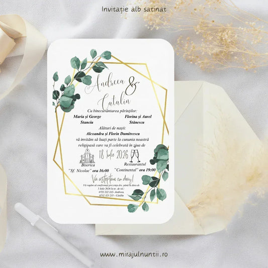 Invitație de nuntă cod Magnific C.12 pe carton alb satinat, cu ramuri de eucalipt în colțuri și chenar auriu geometric, lângă un plic crem.