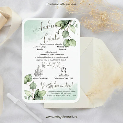 Invitație de nuntă cod Magnific C.16 pe carton alb satinat, cu acuarelă verde mentă și ramuri de eucalipt în colțuri, lângă un plic crem.