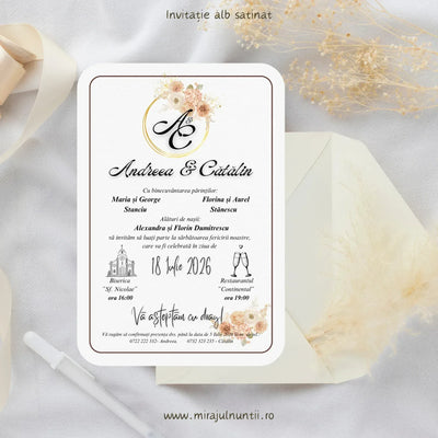 Invitație de nuntă cod Magnific C.44 pe carton alb satinat, cu monogramă într-un cerc auriu, flori pudrate și chenar fin, lângă un plic crem.