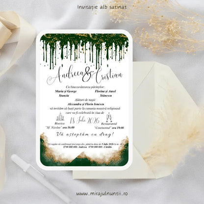 Invitație de nuntă cod Magnific C.34 pe carton alb satinat, cu picături de vopsea verde smarald sus și acuarelă verde cu sclipici auriu jos, lângă un plic crem.