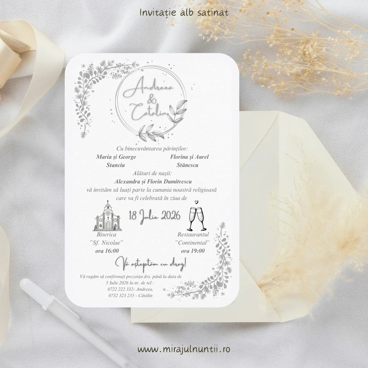 Invitație de nuntă cod Magnific C.13.2 pe carton alb satinat, cu ramuri argintii în colțuri și nume într-un cerc argintiu, lângă un plic crem.