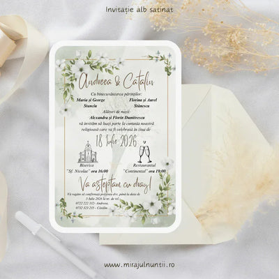 Invitație de nuntă cod Magnific C.10 pe carton alb satinat, cu fundal verde salvie, ramuri verzi, flori albe și chenar auriu subțire, lângă un plic crem.