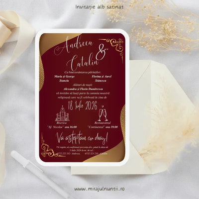 Invitație de nuntă cod Magnific C.14 vișinie, cu valuri aurii pe margini, ornamente aurii în colțuri și text alb caligrafic, lângă un plic crem.