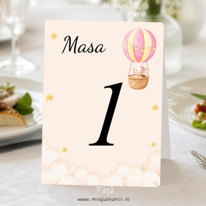 Număr de masă botez, fața, cu balon cu aer cald roz și galben cu iepuraș în dreapta sus, nori pufoși și steluțe galbene, „Masa 1”, cod Magnific B.4-20004