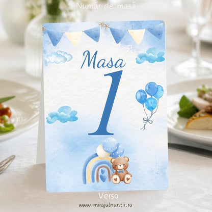 Număr de masă botez B.12-20012, verso: același design cu „Masa 1” albastru, ghirlandă de stegulețe, nori, baloane bleu și ursuleț cu curcubeu, pe fond acuarelă bleu, tipărit față-verso