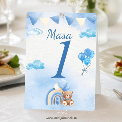 Număr de masă botez B.12-20012, față: „Masa” și cifra „1” mari, albastre, pe fond acuarelă bleu, cu ghirlandă de stegulețe albastre și crem sus, nori bleu pe margini, buchet de baloane bleu în dreapta și ursuleț maro cu papion bleu lângă un curcubeu cu baloane, jos