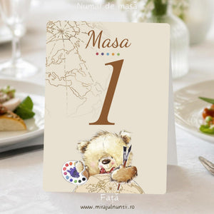 Fața numărului de masă de botez B. 7614 pe carton crem: „Masa 1” maro cu buline colorate ca o paletă, harta lumii în linii sepia sus-stânga și ursuleț pictor cu pensule pe glob pământesc jos