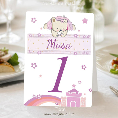 Fața numărului de masă de botez B. 3507: ursuleț cu glugă roz de unicorn așezat pe banderola roz cu „Masa”, numărul 1 mare și castel roz cu curcubeu jos