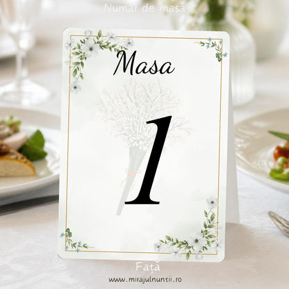 Număr de masă nuntă C.10, față: „Masa” scris caligrafic și numărul 1 mare, negru, peste un buchețel de floricele albe estompat; flori albe cu frunze verzi, floricele albastre și ramă aurie fină pe fond verde salvie pal