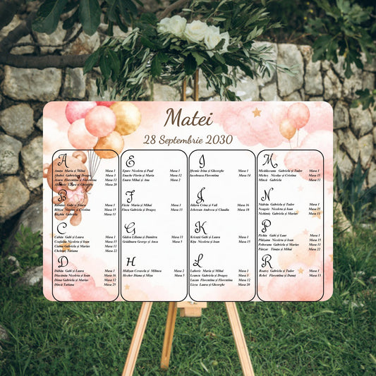 Opis botez orizontal 42 x 30 cm cu ursuleț cu baloane roz pudrat și aurii, nori roz și steluțe, numele „Matei” și data mari, centrate sus, listă invitați pe litere, chenar alb, pe șevalet, cod Magnific B.23-20023