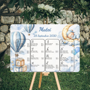 Opis botez orizontal 42 x 30 cm cod Magnific B.20-20020 pe șevalet, cu baloane cu aer cald în dungi bleu în colțul din stânga sus, ursuleț care doarme pe lună în colțul din dreapta sus și cuburi BOY în stânga jos; numele Matei și data 28 Septembrie 2030, lista invitaților în ordine alfabetică, pe litere, în patru coloane (la alegere se poate face și grupată pe mese).