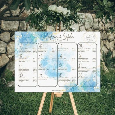 Opis nuntă orizontal 42 x 30 cm cod Magnific C.11 pe șevalet, cu fundal în acuarelă albastră și auriu, monogramă și lista invitaților în patru coloane.