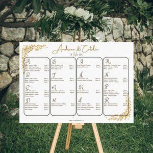 Opis nuntă orizontal 42 x 30 cm cod Magnific C.13 pe șevalet în grădină, cu numele mirilor scrise caligrafic cu auriu, ramuri aurii în colțuri și lista invitaților în patru coloane cu chenare rotunjite.