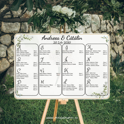 Opis nuntă orizontal 42 x 30 cm cod C.10 pe șevalet: numele de exemplu „Andreea & Cătălin” și data scrise caligrafic, lista invitaților alfabetic în patru coloane cu contur rotunjit, flori albe cu frunze verzi, floricele albastre și ramă aurie fină pe fond verde salvie pal