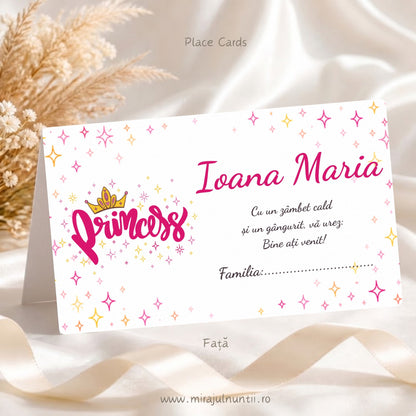 Plic de bani botez personalizat, fața: inscripția Princess cu coroniță aurie în stânga, numele Ioana Maria, mesaj de bun venit și rândul Familia, pe fond alb cu steluțe roz și aurii, cod B. 6017