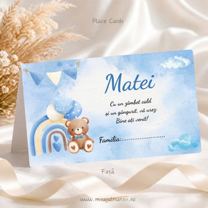 Plic de bani botez personalizat B.12-20012, față: numele Matei în albastru, mesaj de bun venit și rândul Familia, ursuleț maro cu papion bleu lângă curcubeu și baloane, stegulețe și nori bleu pe fond acuarelă bleu