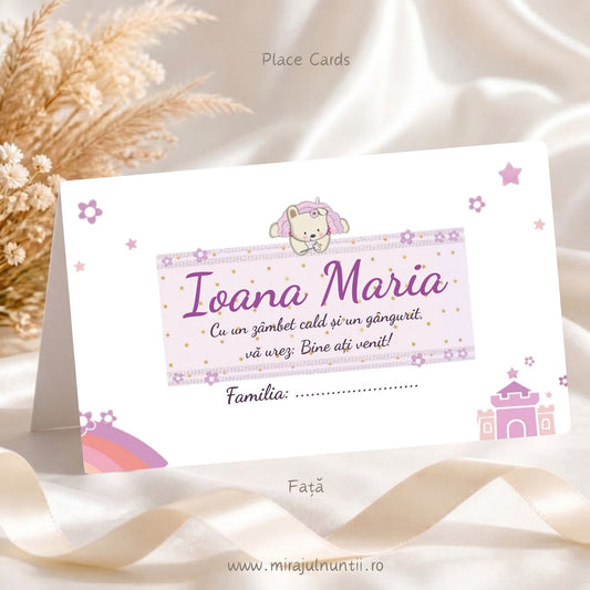Plic de bani botez personalizat B. 3507, față: ursulețul cu glugă de unicorn stă pe banderola roz cu buline, cu numele Ioana Maria și mesajul de bun venit, rândul Familia dedesubt, castel roz-lila jos în dreapta și curcubeu jos în stânga