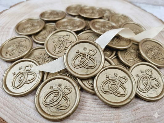 Detaliu sigiliu din ceară auriu cu model verighete aplicat pe un plic de nuntă elegant, alături de accesorii de papetărie premium de la Mirajul Nunții.1